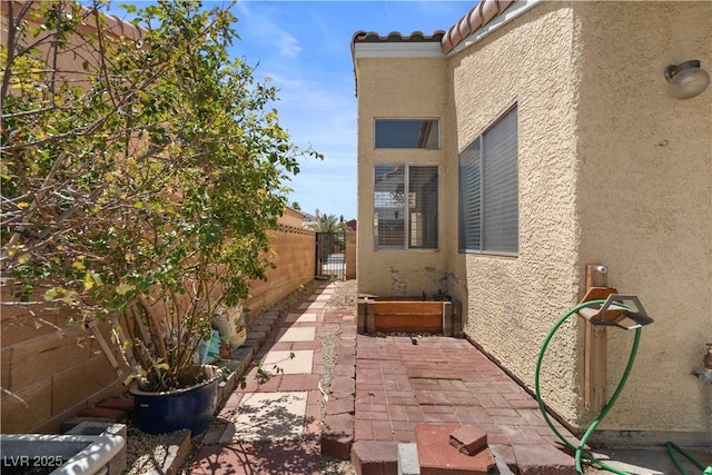 920 Serpentina Ave, Las Vegas, NV 89123 - view of side of home with stucco siding, a gate, and a tiled roof