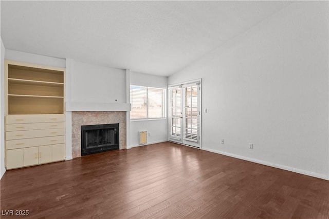 920 Serpentina Ave, Las Vegas, NV 89123 - unfurnished living room with wood finished floors, a tile fireplace, and vaulted ceiling