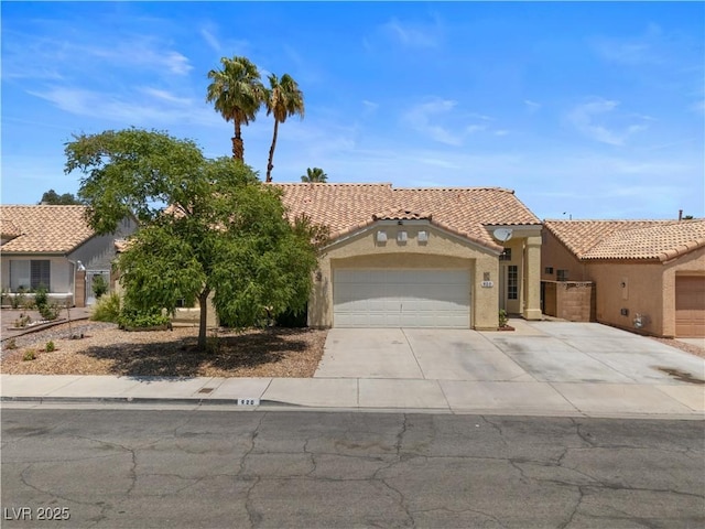 920 Serpentina Ave, Las Vegas, NV 89123 - mediterranean / spanish house featuring an attached garage, concrete driveway, a tile roof, and stucco siding