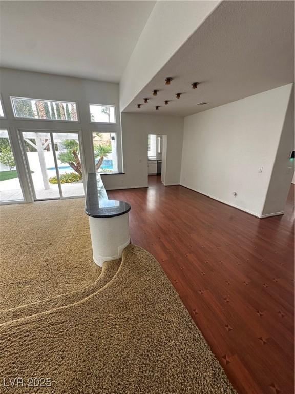 8761 Rainbow Ridge Dr, Las Vegas, NV 89117 - unfurnished living room featuring dark wood-style flooring