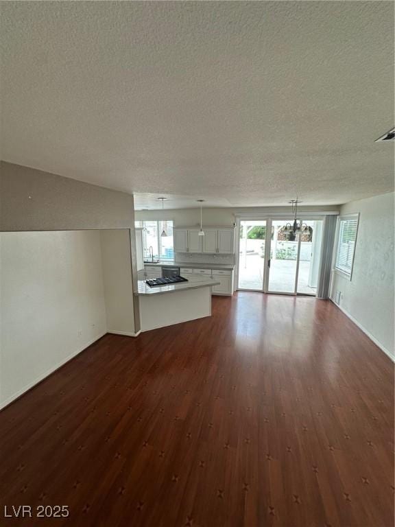 8761 Rainbow Ridge Dr, Las Vegas, NV 89117 - unfurnished living room with a textured ceiling and dark wood finished floors