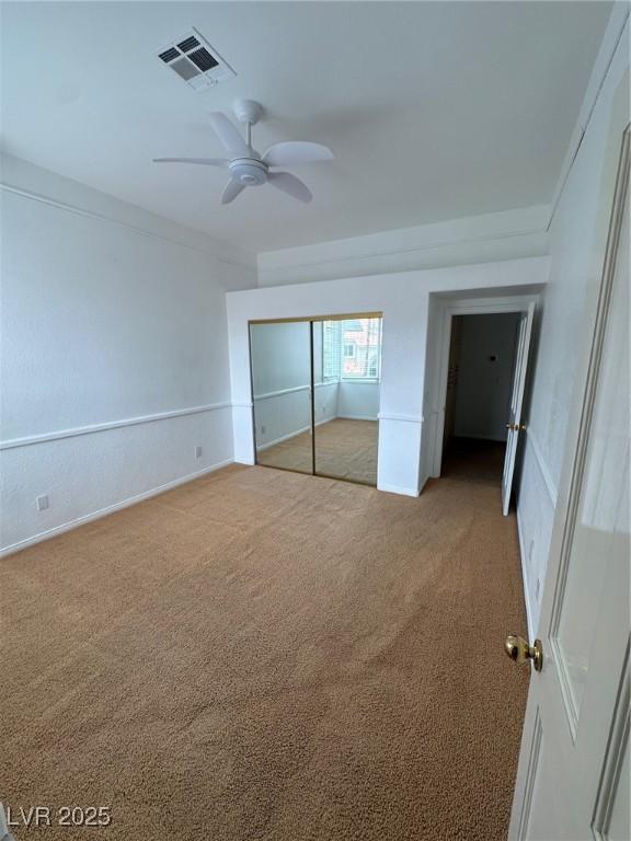 8761 Rainbow Ridge Dr, Las Vegas, NV 89117 - unfurnished bedroom with light colored carpet, a closet, and a ceiling fan