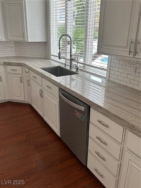 8761 Rainbow Ridge Dr, Las Vegas, NV 89117 - kitchen with stainless steel dishwasher, dark wood-style flooring, white cabinets, and tasteful backsplash