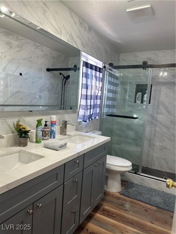 8901 Kingswood Dr, Las Vegas, NV 89147 - full bath with a marble finish shower, double vanity, a textured ceiling, and wood finished floors