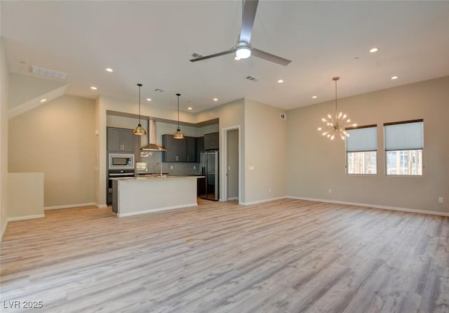646 Spotted Falcon St, Las Vegas, NV 89138 - kitchen featuring stainless steel appliances, open floor plan, wall chimney exhaust hood, recessed lighting, and light wood-style floors