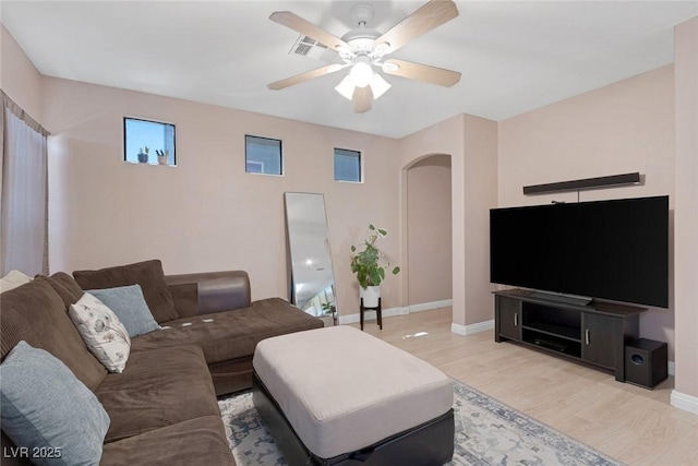 6217 Lapilli Ave, Las Vegas, NV 89139 - living area with arched walkways, a ceiling fan, and light wood-style floors