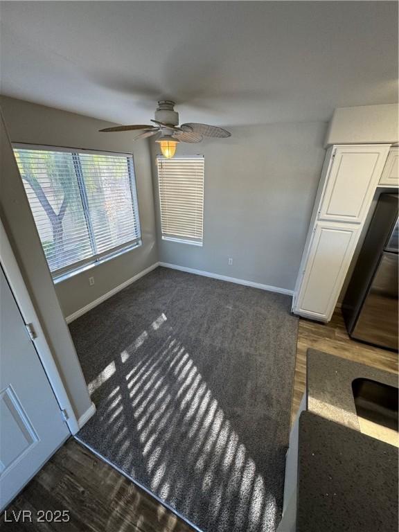 5710 E Tropicana Ave Unit 2225, Las Vegas, NV 89122 - unfurnished dining area featuring a ceiling fan and dark wood finished floors