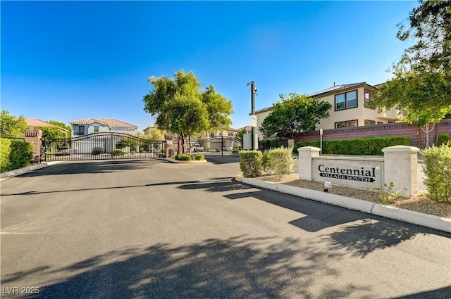 9021 Rendon St, Las Vegas, NV 89143 - view of asphalt road featuring a gate, a gated entry, and curbs
