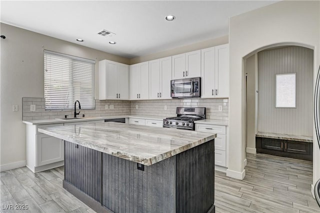 9021 Rendon St, Las Vegas, NV 89143 - kitchen with appliances with stainless steel finishes, light stone counters, light wood-style floors, white cabinets, and recessed lighting
