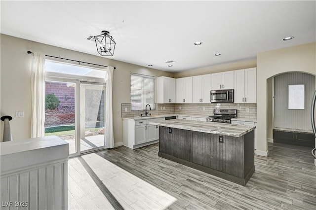 9021 Rendon St, Las Vegas, NV 89143 - kitchen with appliances with stainless steel finishes, white cabinets, backsplash, light wood-style flooring, and recessed lighting