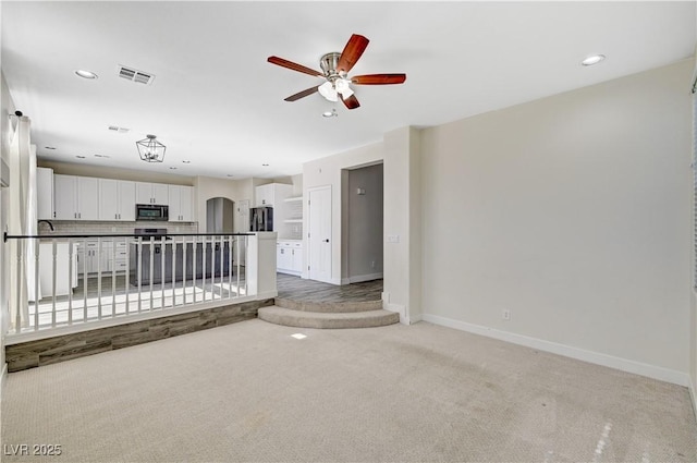 9021 Rendon St, Las Vegas, NV 89143 - unfurnished living room with light carpet, ceiling fan, arched walkways, and recessed lighting