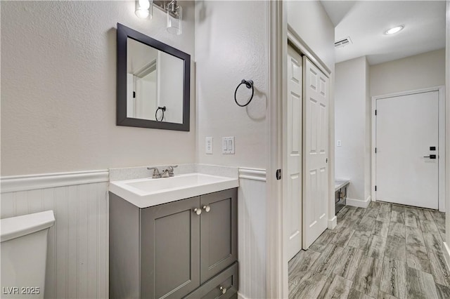 9021 Rendon St, Las Vegas, NV 89143 - bathroom featuring vanity, wood finished floors, and a wainscoted wall