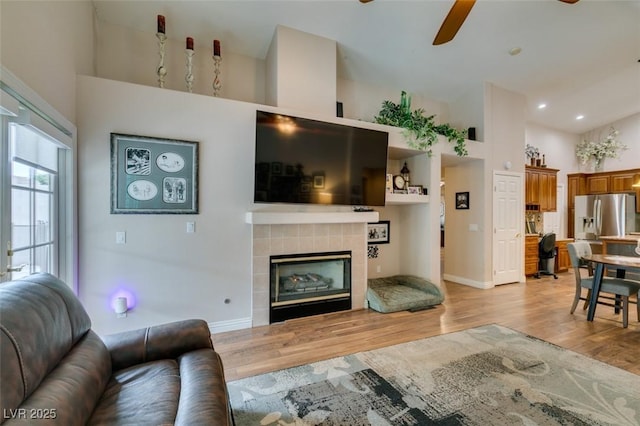 1779 Antelope Valley Ave, Henderson, NV 89012 - living room featuring a high ceiling, light wood-style flooring, ceiling fan, a tile fireplace, and recessed lighting
