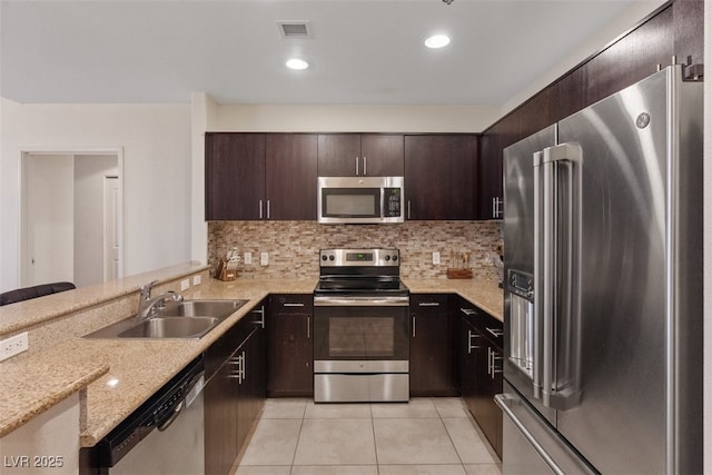 8255 Las Vegas Blvd Unit 1905, Las Vegas, NV 89123 - kitchen featuring stainless steel appliances, light tile patterned floors, backsplash, dark brown cabinets, and light stone countertops