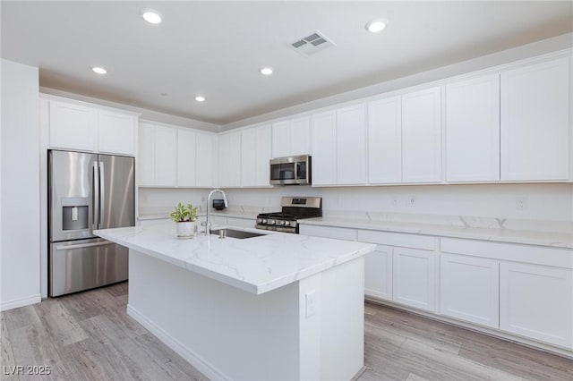 835 Aurelie Ridge St, Henderson, NV 89011 - kitchen with stainless steel appliances, light wood-style flooring, white cabinetry, light stone countertops, and recessed lighting