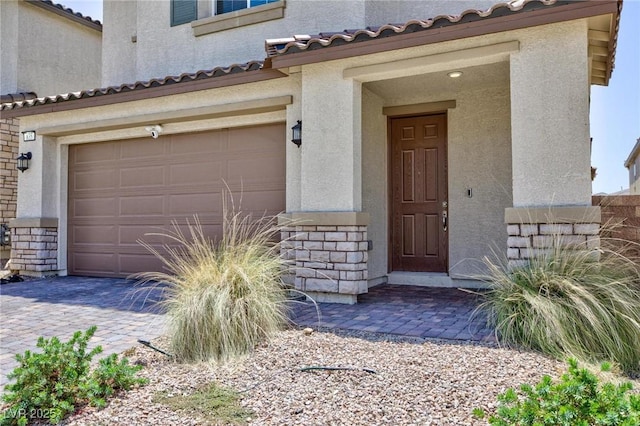 835 Aurelie Ridge St, Henderson, NV 89011 - doorway to property with stucco siding, stone siding, driveway, a garage, and a tiled roof