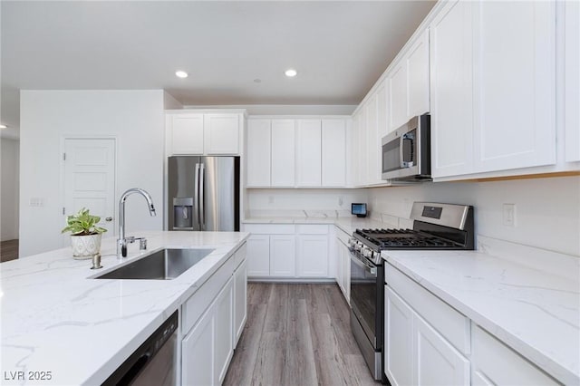835 Aurelie Ridge St, Henderson, NV 89011 - kitchen with stainless steel appliances, recessed lighting, light wood finished floors, and white cabinetry