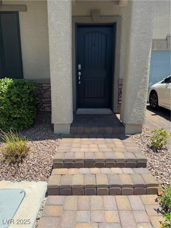 5414 Enchanted Rose St, Las Vegas, NV 89148 - doorway to property with stucco siding and a garage