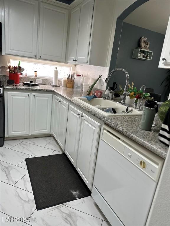 10265 Moth Orchid Ct, Las Vegas, NV 89183 - kitchen featuring dishwasher, light marble finish floors, and white cabinetry