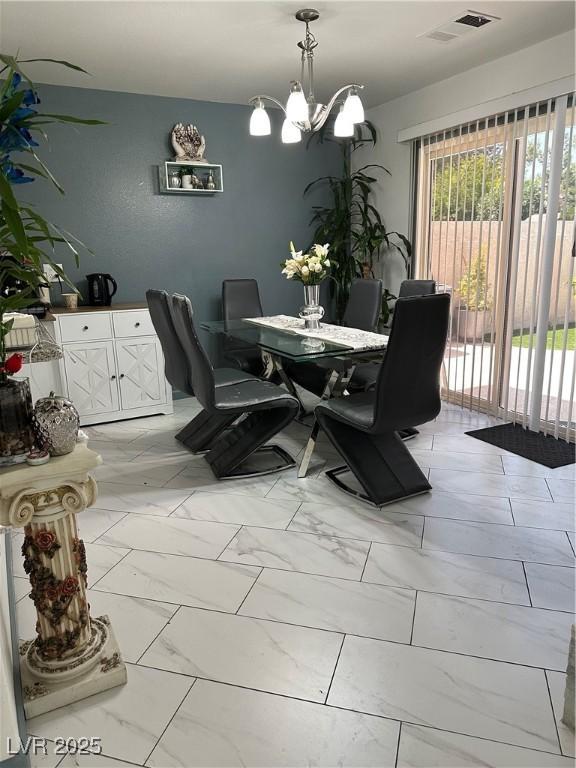 10265 Moth Orchid Ct, Las Vegas, NV 89183 - dining space featuring light marble finish flooring and a chandelier