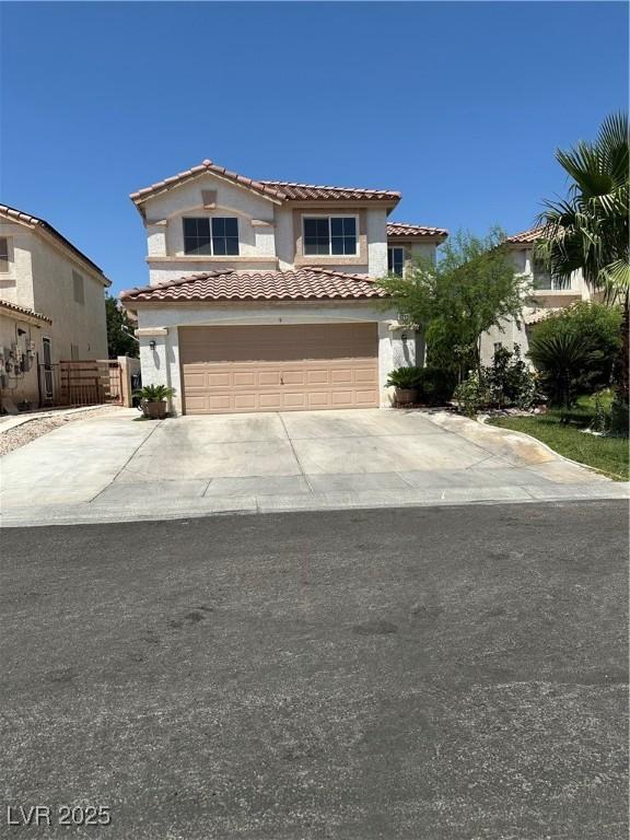 10265 Moth Orchid Ct, Las Vegas, NV 89183 - mediterranean / spanish house featuring stucco siding, a garage, a tiled roof, and driveway