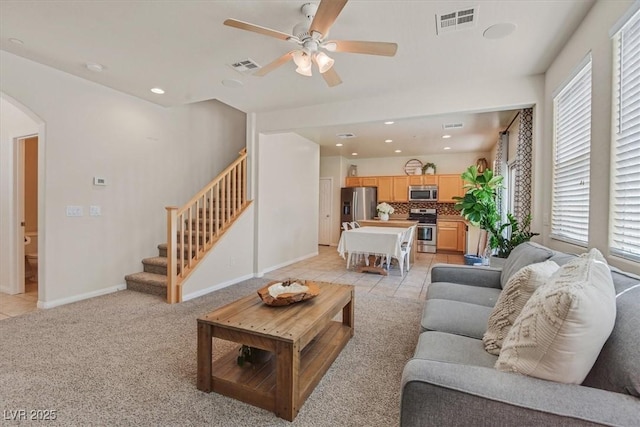 953 Via Del Tramonto St, Henderson, NV 89011 - living area with arched walkways, stairway, a ceiling fan, light tile patterned floors, and light carpet
