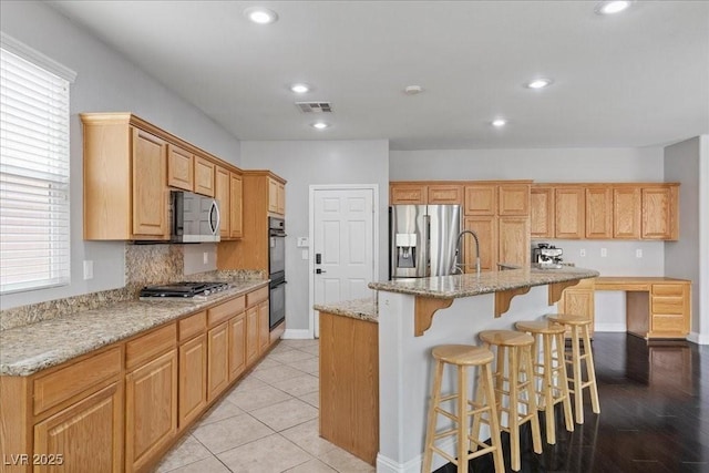 10300 S Dapple Gray Rd, Las Vegas, NV 89178 - kitchen with appliances with stainless steel finishes, a breakfast bar, a center island with sink, recessed lighting, and light stone counters