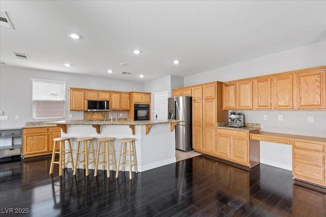 10300 S Dapple Gray Rd, Las Vegas, NV 89178 - kitchen with stainless steel appliances, dark wood-style floors, a breakfast bar area, light stone counters, and recessed lighting