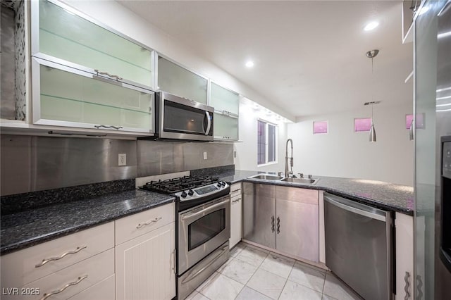 10414 Midseason Mist St, Las Vegas, NV 89183 - kitchen featuring appliances with stainless steel finishes, dark stone counters, light marble finish floors, glass insert cabinets, and recessed lighting