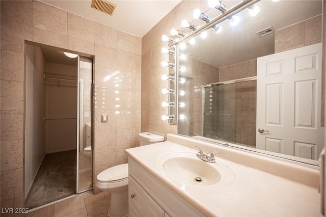 10414 Midseason Mist St, Las Vegas, NV 89183 - full bathroom with tile walls, tile patterned flooring, tiled shower, vanity, and a spacious closet