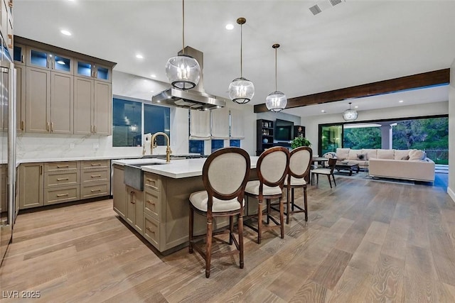 11906 Port Labelle Dr, Las Vegas, NV 89141 - kitchen featuring a kitchen island with sink, gray cabinetry, light wood finished floors, light countertops, and a kitchen breakfast bar