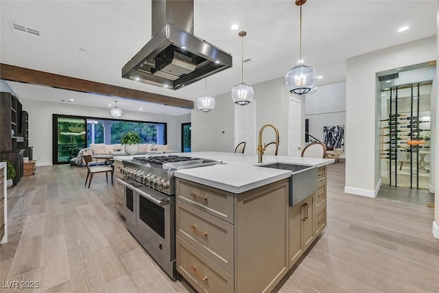11906 Port Labelle Dr, Las Vegas, NV 89141 - kitchen with double oven range, exhaust hood, open floor plan, a kitchen island with sink, and light wood-type flooring