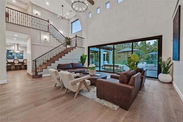 11906 Port Labelle Dr, Las Vegas, NV 89141 - living area with a high ceiling, wood finished floors, a chandelier, healthy amount of natural light, and stairs