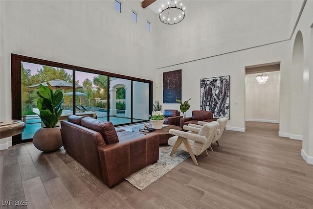 11906 Port Labelle Dr, Las Vegas, NV 89141 - living area with a towering ceiling, a chandelier, light wood-type flooring, and arched walkways