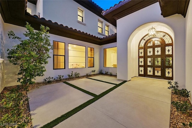 11906 Port Labelle Dr, Las Vegas, NV 89141 - view of exterior entry with stucco siding, a tile roof, and a patio