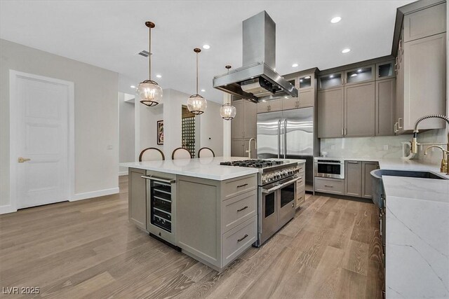 11906 Port Labelle Dr, Las Vegas, NV 89141 - kitchen with wine cooler, island range hood, double oven range, gray cabinetry, and recessed lighting