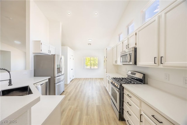 2403 Sexton Ave, North Las Vegas, NV 89031 - kitchen with appliances with stainless steel finishes, light countertops, light wood-style flooring, white cabinets, and recessed lighting