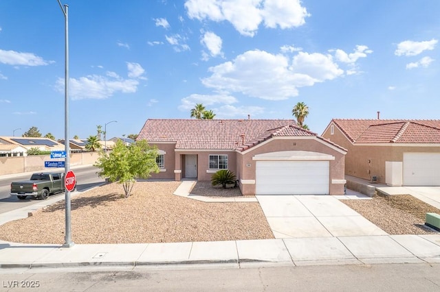 2403 Sexton Ave, North Las Vegas, NV 89031 - view of front facade featuring stucco siding, an attached garage, a tile roof, and concrete driveway