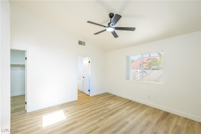 2403 Sexton Ave, North Las Vegas, NV 89031 - unfurnished bedroom featuring wood finished floors, vaulted ceiling, a spacious closet, connected bathroom, and a closet