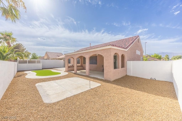 2403 Sexton Ave, North Las Vegas, NV 89031 - back of house featuring a tiled roof, stucco siding, a patio, and a fenced backyard