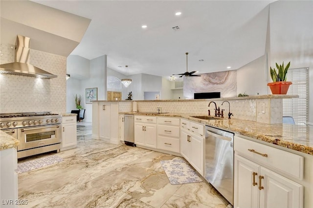 1970 Del Font Ct, Las Vegas, NV 89117 - kitchen featuring stainless steel appliances, wall chimney exhaust hood, tasteful backsplash, light stone counters, and ceiling fan
