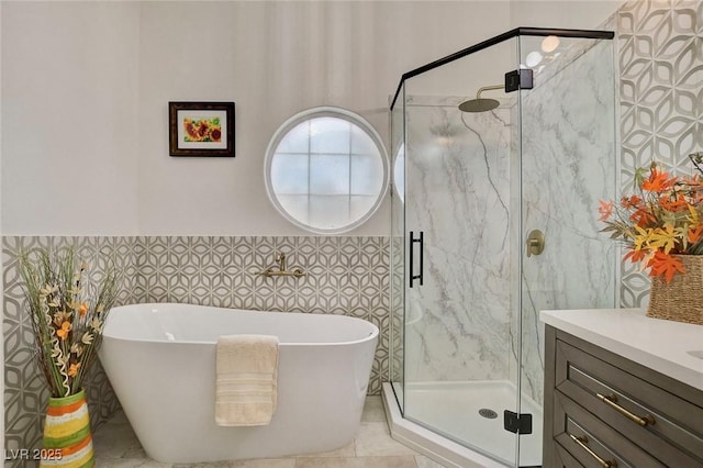 1970 Del Font Ct, Las Vegas, NV 89117 - full bathroom featuring a freestanding tub, tile walls, a marble finish shower, vanity, and a wainscoted wall