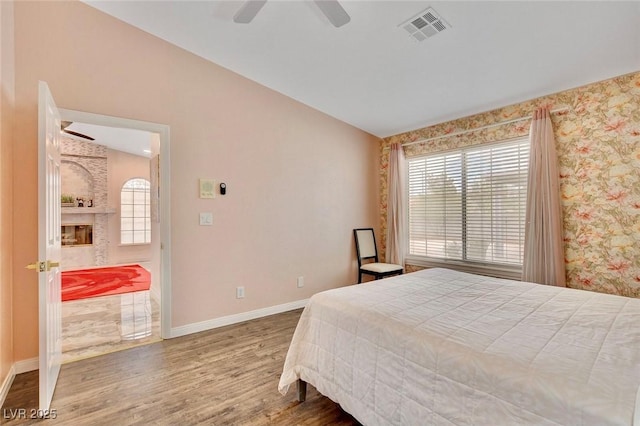 1970 Del Font Ct, Las Vegas, NV 89117 - bedroom with wood finished floors, a large fireplace, and a ceiling fan
