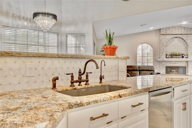 1970 Del Font Ct, Las Vegas, NV 89117 - kitchen featuring stainless steel dishwasher, lofted ceiling, light stone counters, decorative backsplash, and open floor plan
