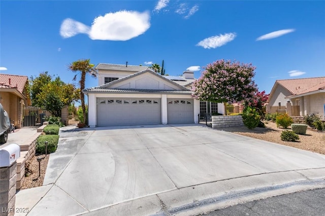5505 Excelsior Springs Ln, Las Vegas, NV 89130 - view of front of property with an attached garage, driveway, a tiled roof, roof mounted solar panels, and stucco siding