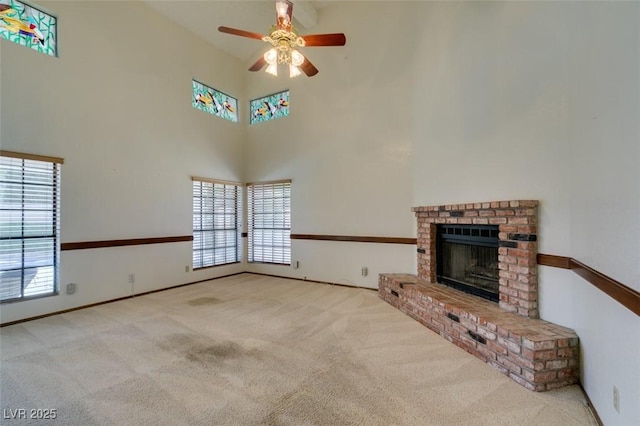 5505 Excelsior Springs Ln, Las Vegas, NV 89130 - unfurnished living room featuring carpet flooring, a towering ceiling, ceiling fan, plenty of natural light, and a brick fireplace