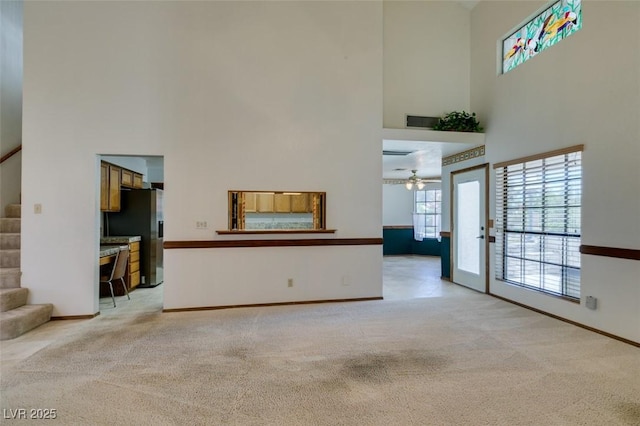 5505 Excelsior Springs Ln, Las Vegas, NV 89130 - unfurnished living room with a towering ceiling, light carpet, stairway, and ceiling fan