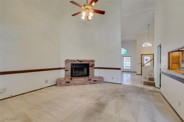 5505 Excelsior Springs Ln, Las Vegas, NV 89130 - unfurnished living room featuring a towering ceiling, carpet, a ceiling fan, a fireplace, and stairway
