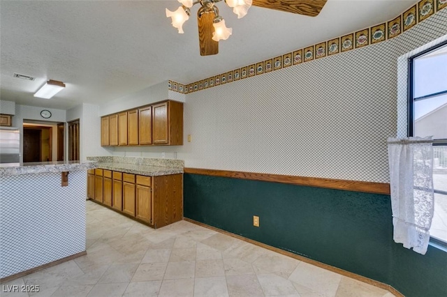 5505 Excelsior Springs Ln, Las Vegas, NV 89130 - kitchen featuring brown cabinets, stainless steel refrigerator, light stone countertops, and a chandelier