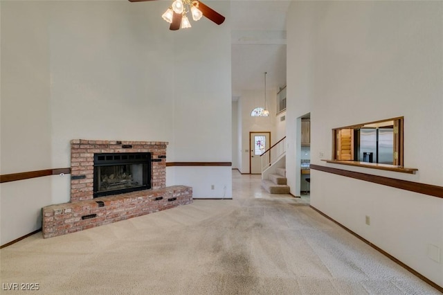 5505 Excelsior Springs Ln, Las Vegas, NV 89130 - unfurnished living room featuring a towering ceiling, carpet, ceiling fan, stairs, and a fireplace